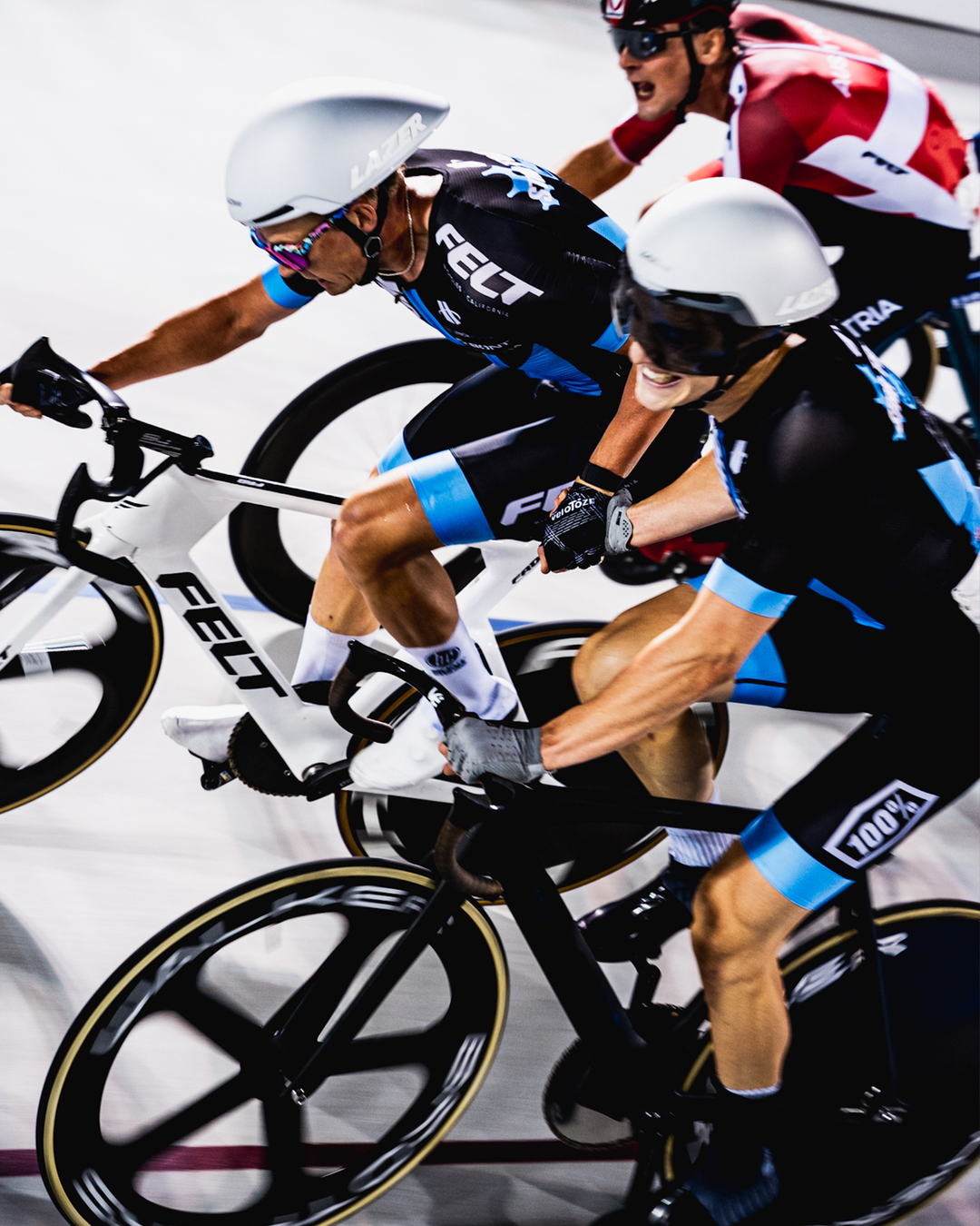 Riders performing a Madison exchange on a velodrome